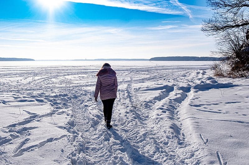 Faire une promenade en solo sur un lac gelé et profiter des rayons du soleil est une agréable activité à faire en hiver.