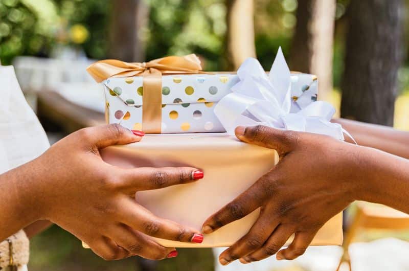 Échange de boîtes emballées entre deux personnes, à l'occasion d'un anniversaire. Un visuel au support d'un article du blog Pour un bonheur simple.